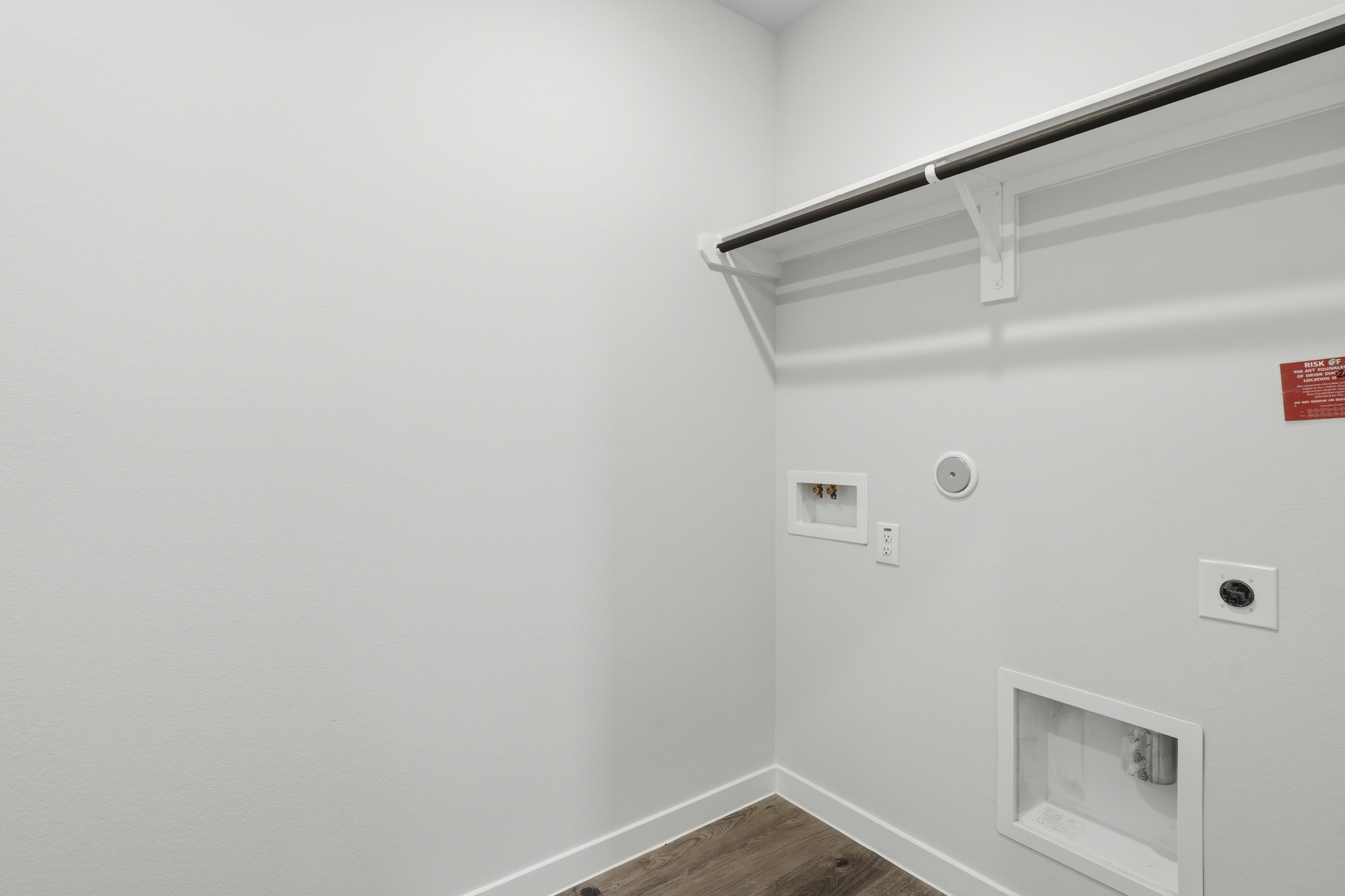 A white wall with a vent and a light fixture.