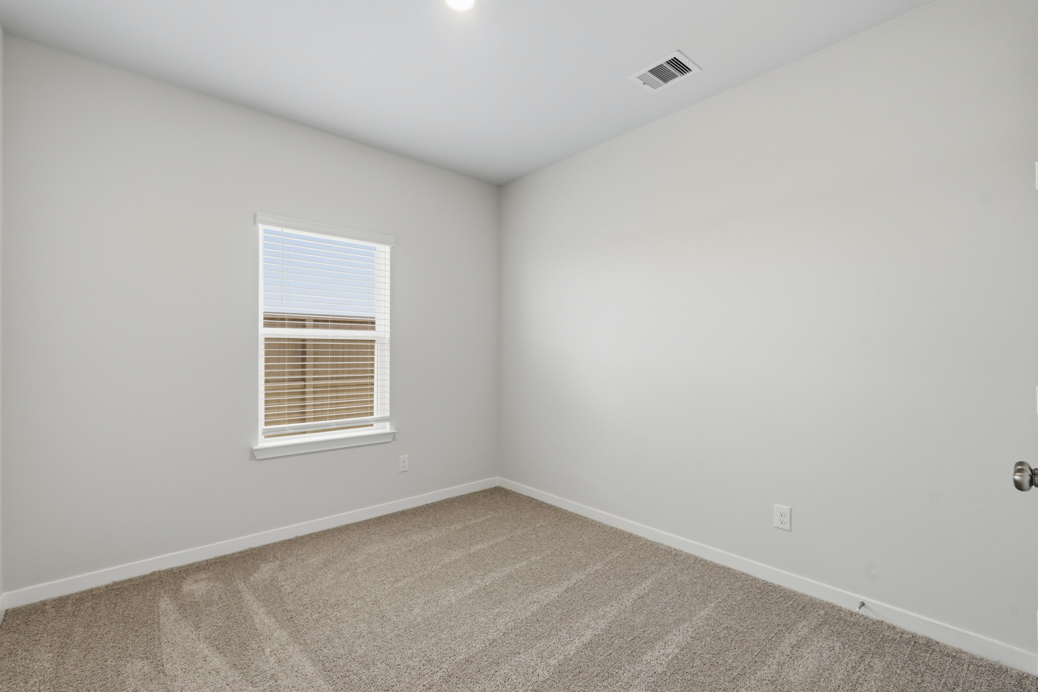 A room with a carpet and a window.