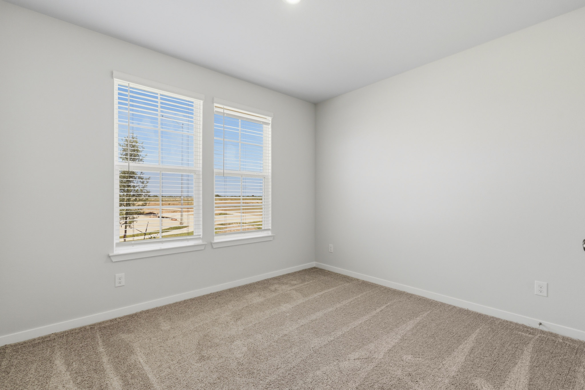 A room with a window and a carpet.
