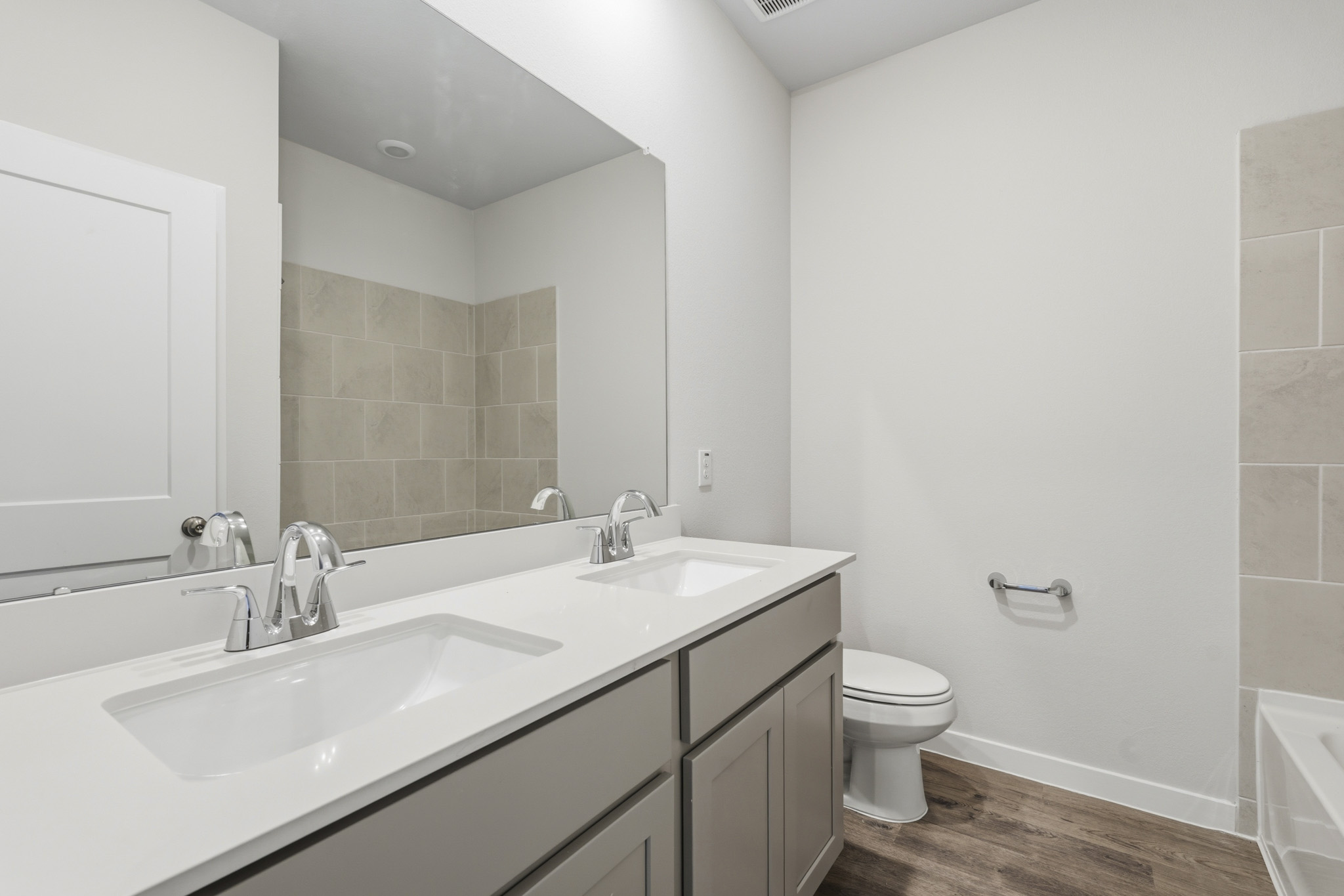 A bathroom with a large mirror.