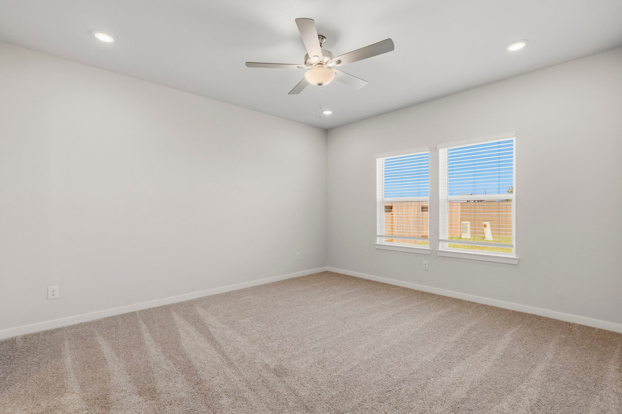 A room with a ceiling fan and a window.