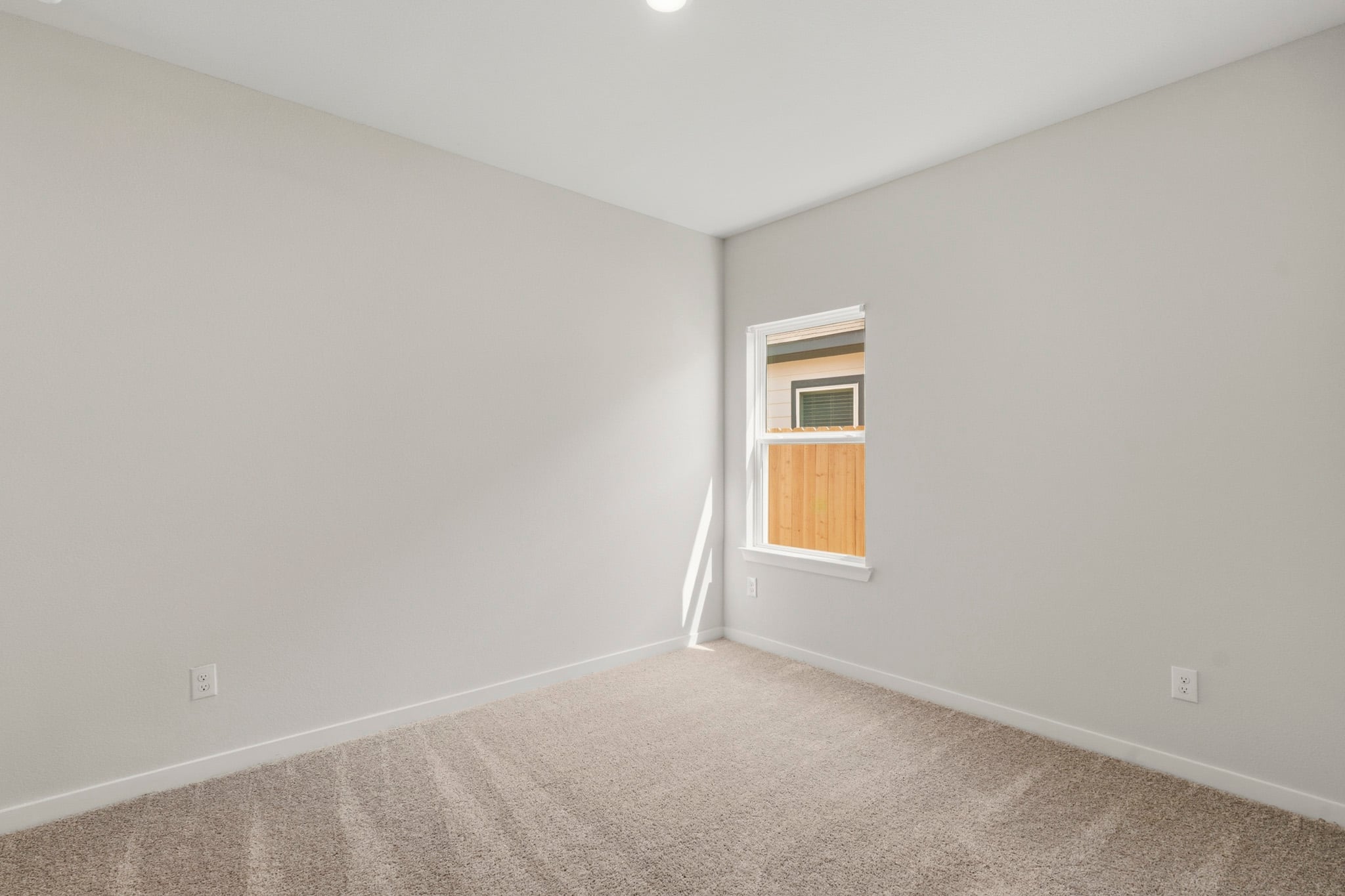 A room with a window and carpet.