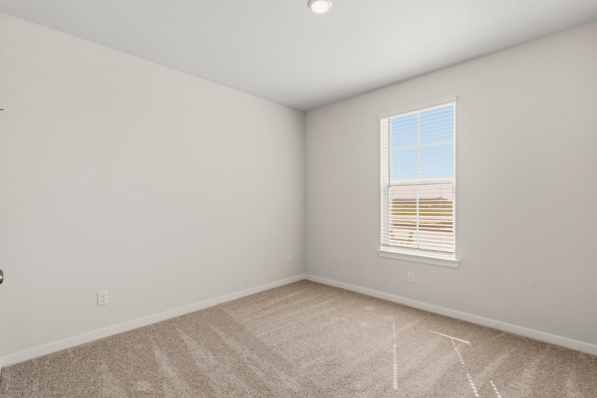 A room with a window and a carpet.
