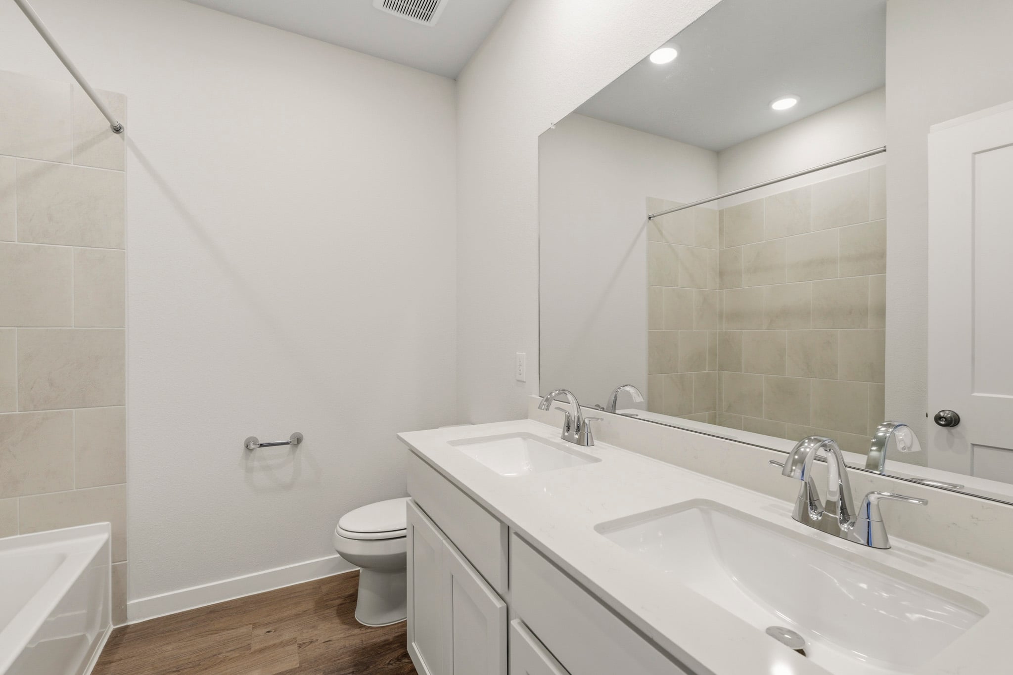 A bathroom with a large mirror.