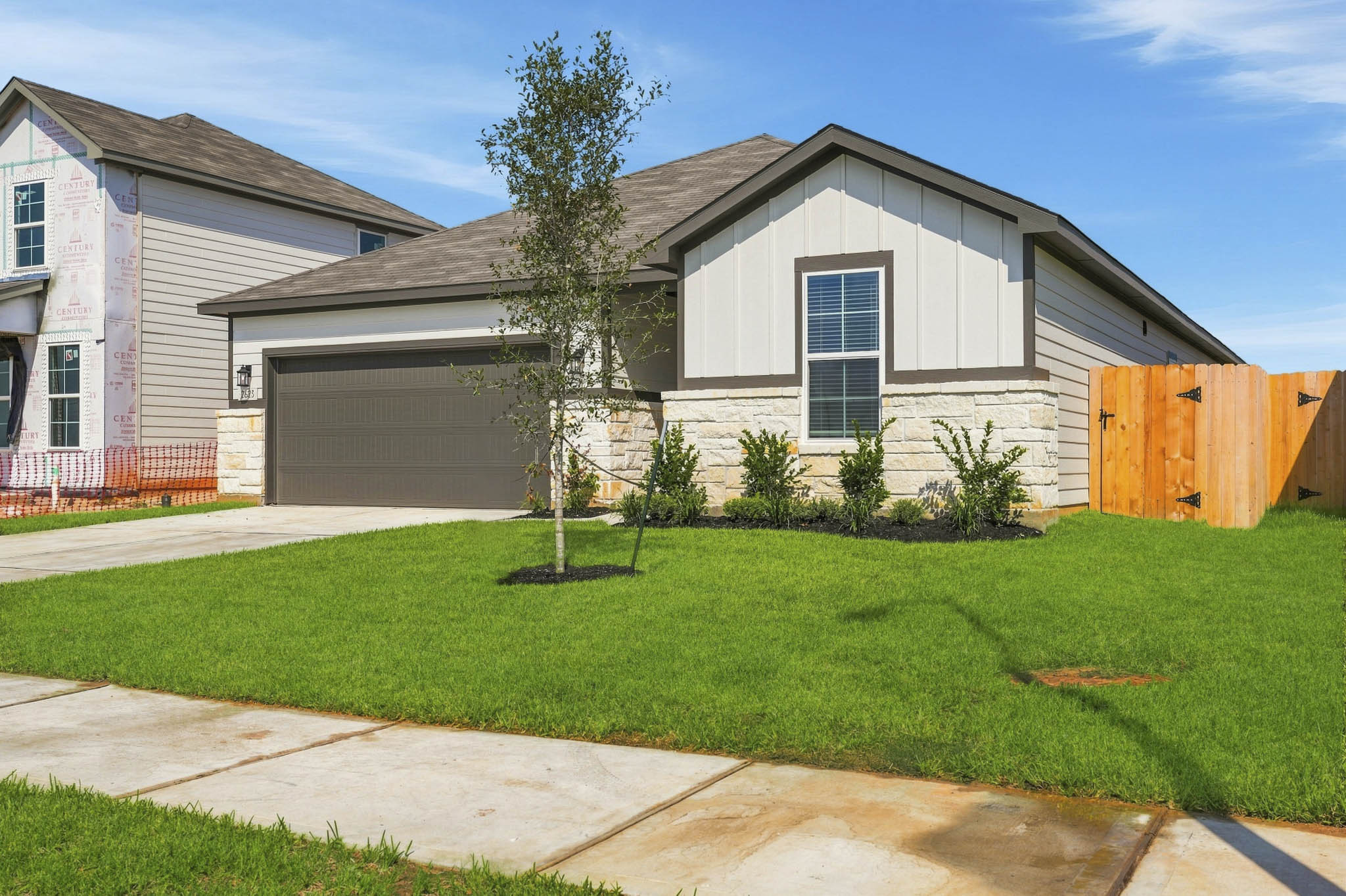 A house with a garage and a tree in the front.