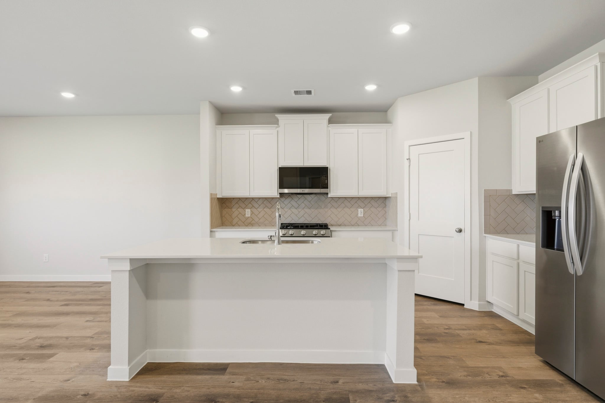 A kitchen with white cabinets.
