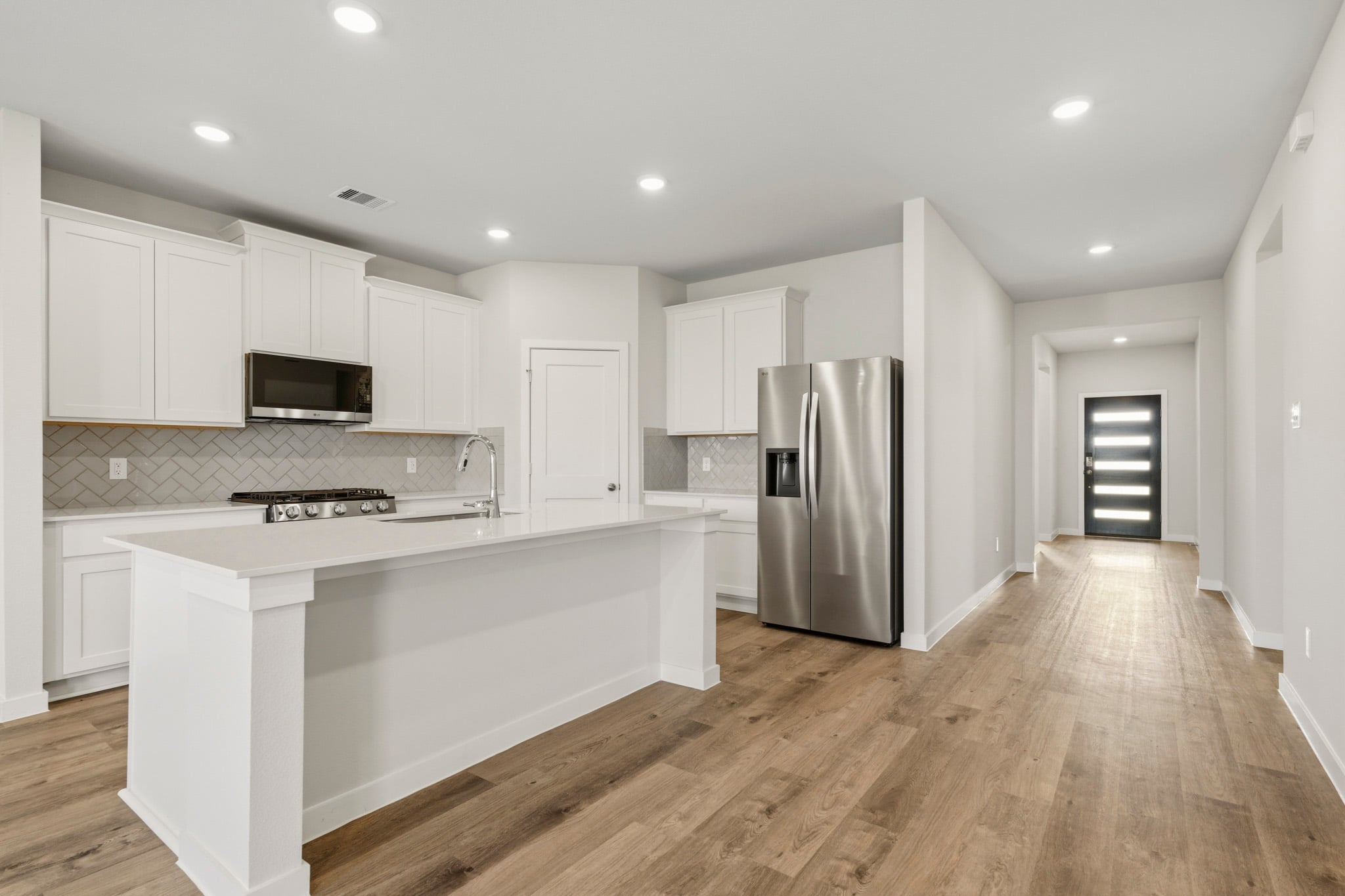 A kitchen with white cabinets.