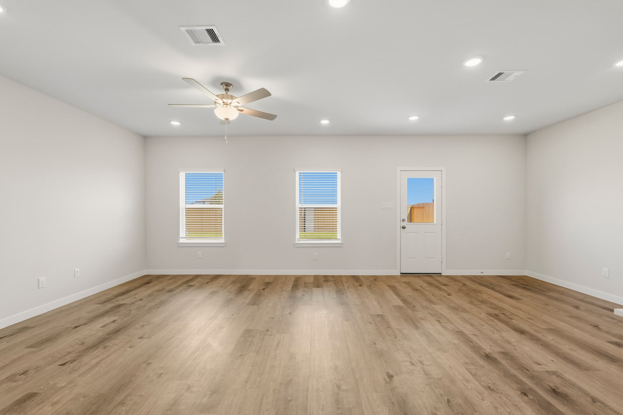 A room with a wood floor and a ceiling fan.