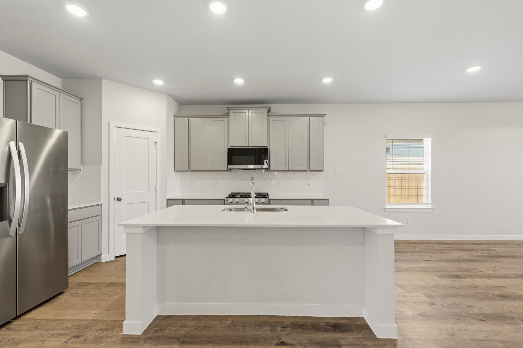A kitchen with white cabinets.