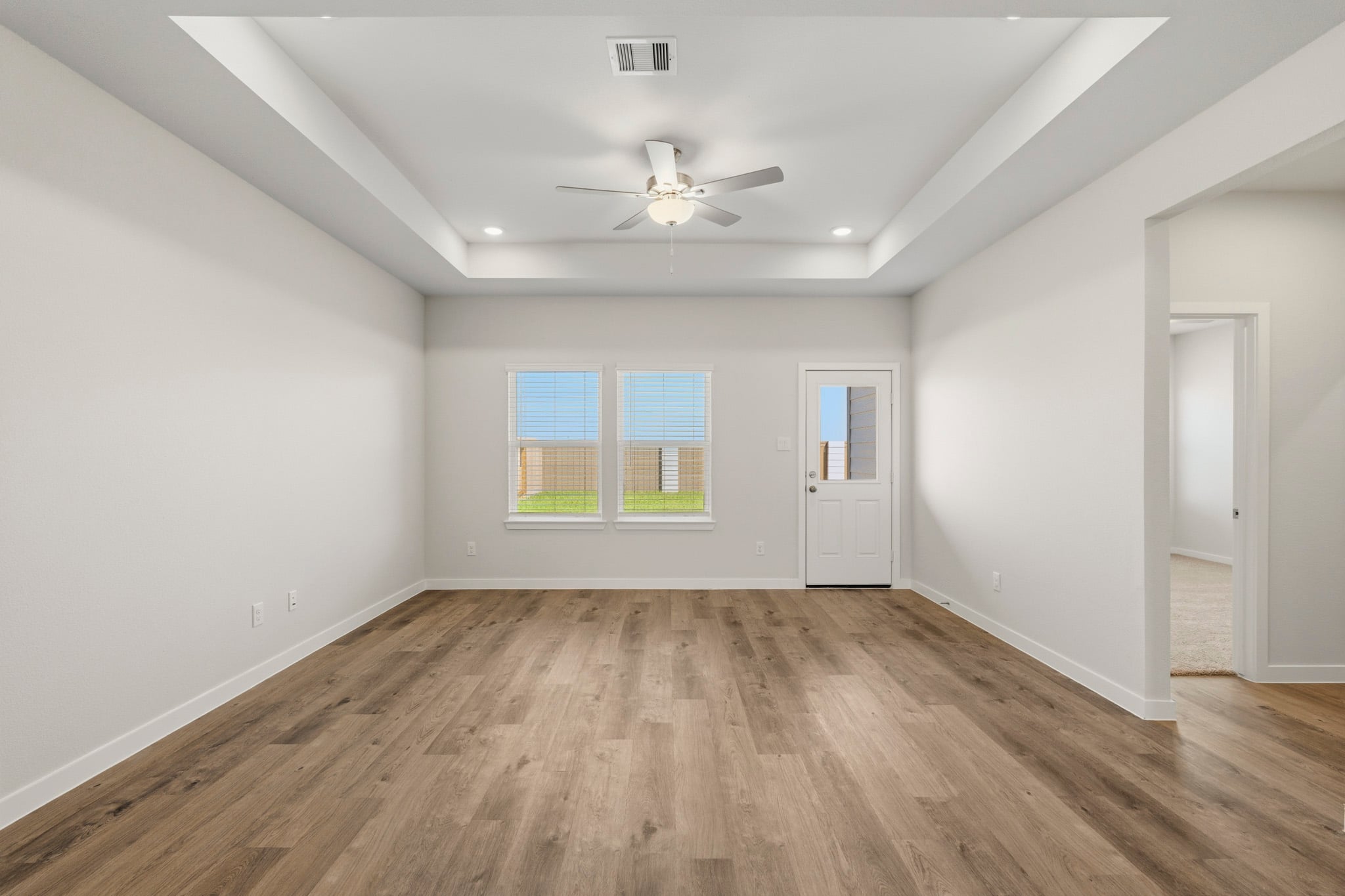 A room with a wood floor and a ceiling fan.