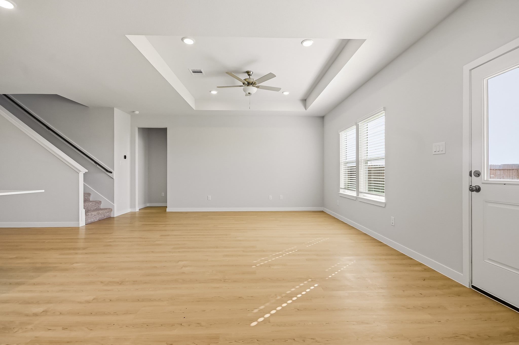 A room with a wood floor and a ceiling fan.