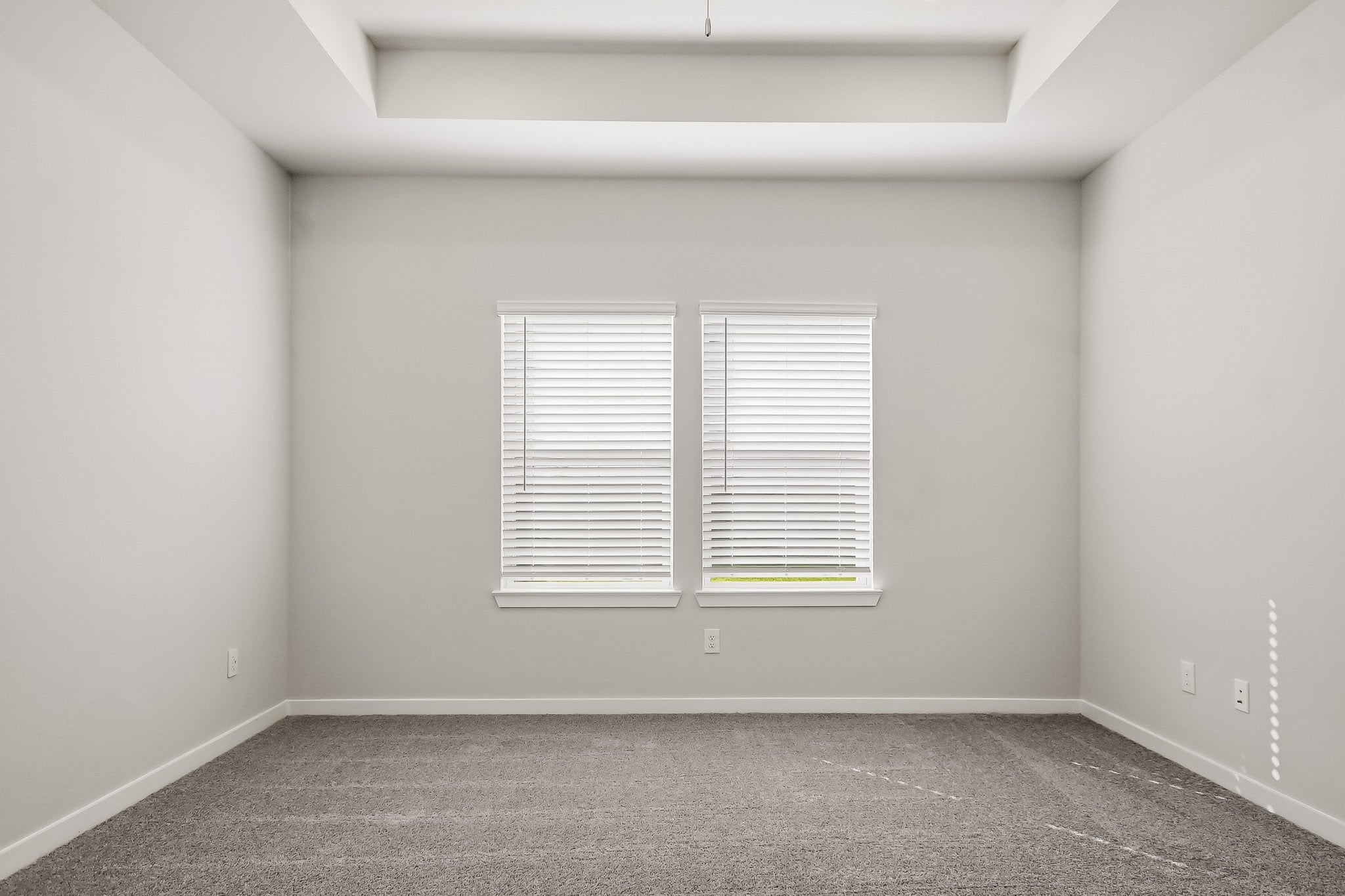 A room with a window and a carpet.
