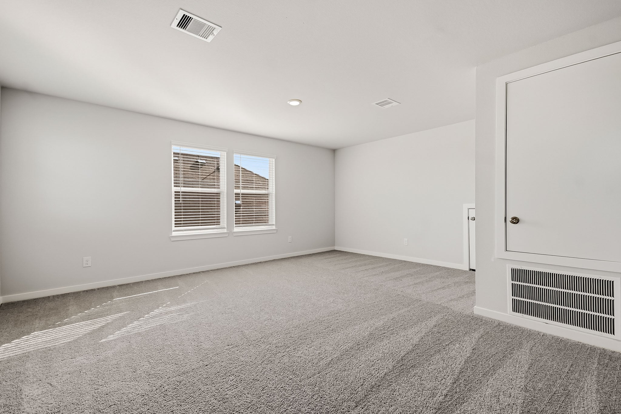 A room with a carpet and windows.
