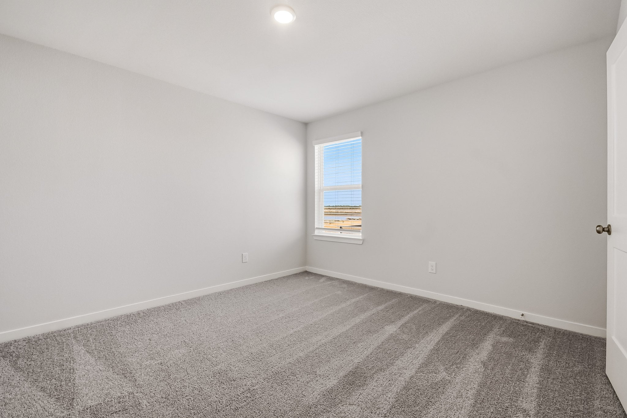 A room with a carpet and a window.