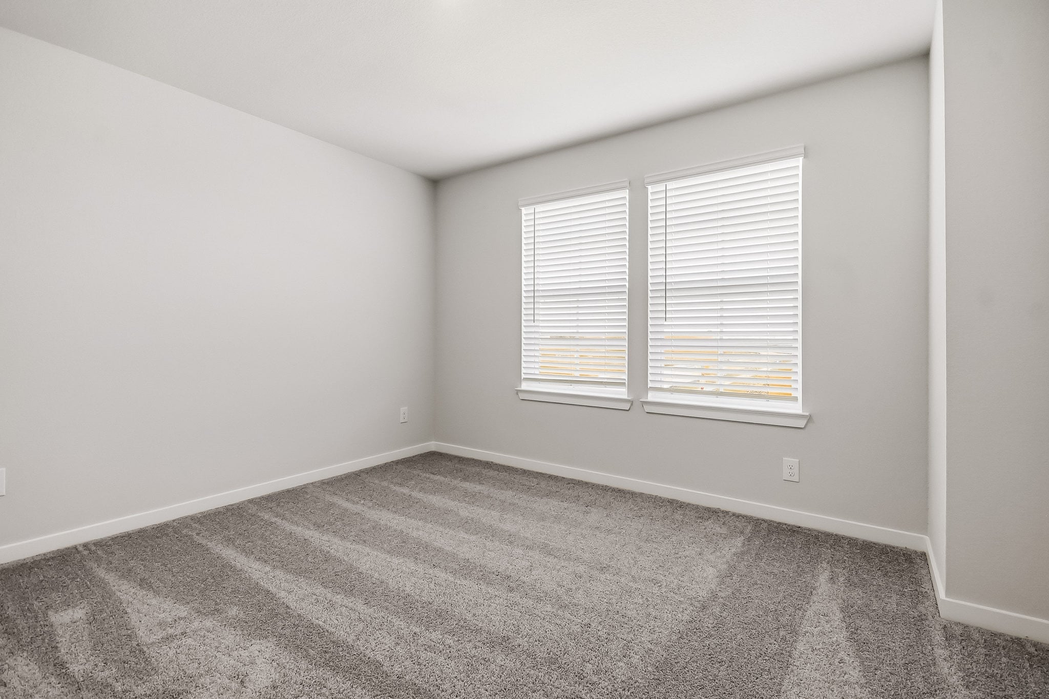 A room with a window and carpet.