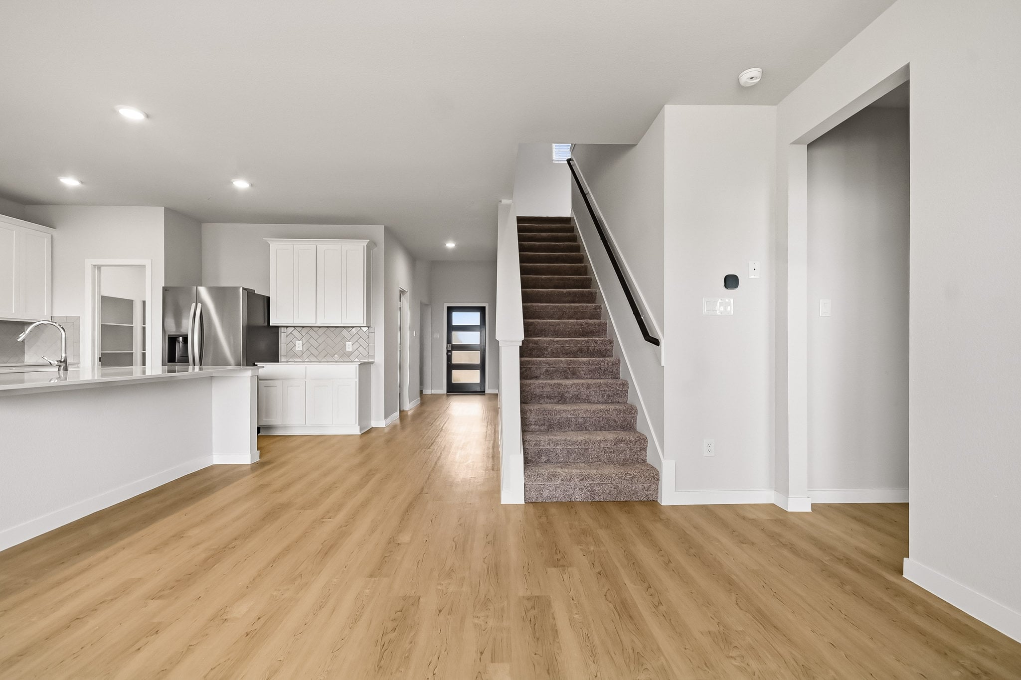 A large kitchen with white walls.