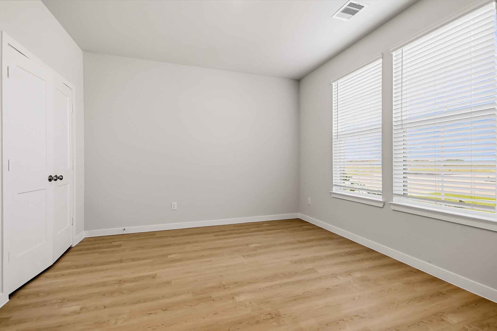 A room with a wood floor and white walls.