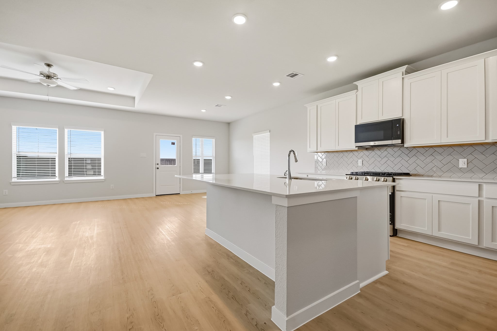 A kitchen with white cabinets.