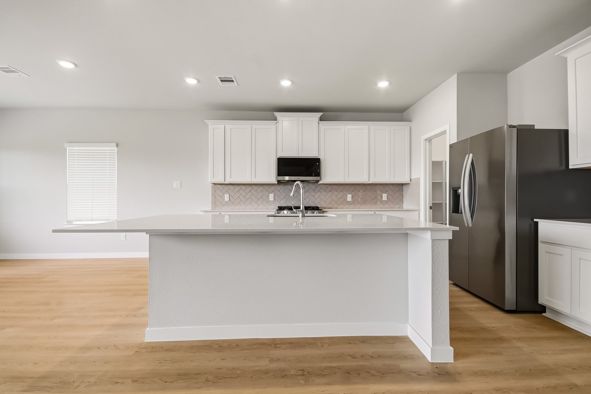 A kitchen with white cabinets.