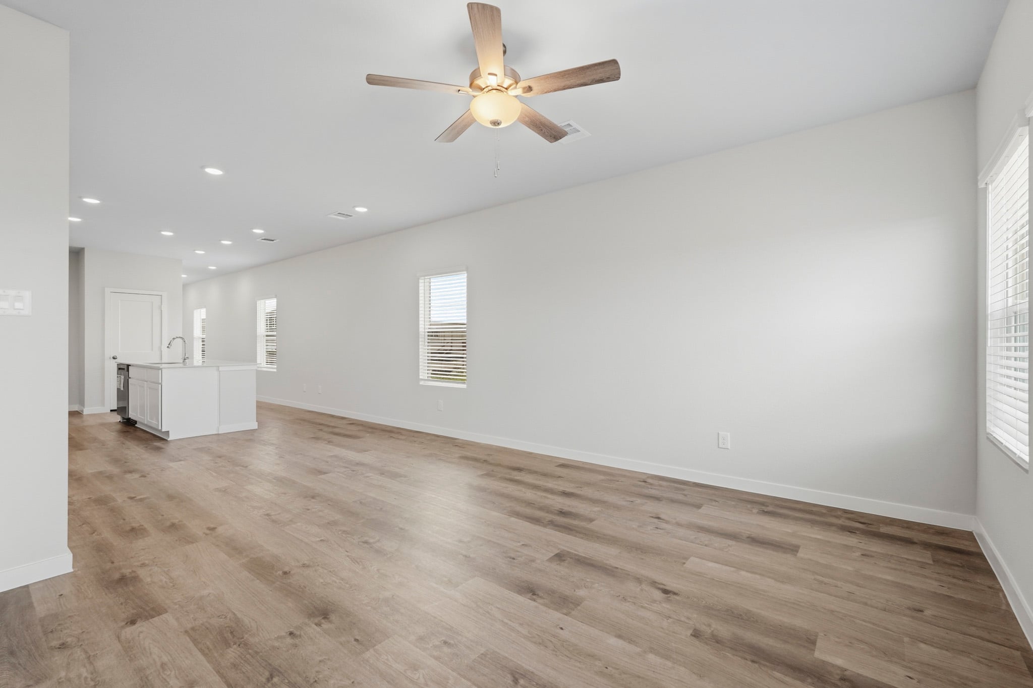 A room with a wood floor and a ceiling fan.
