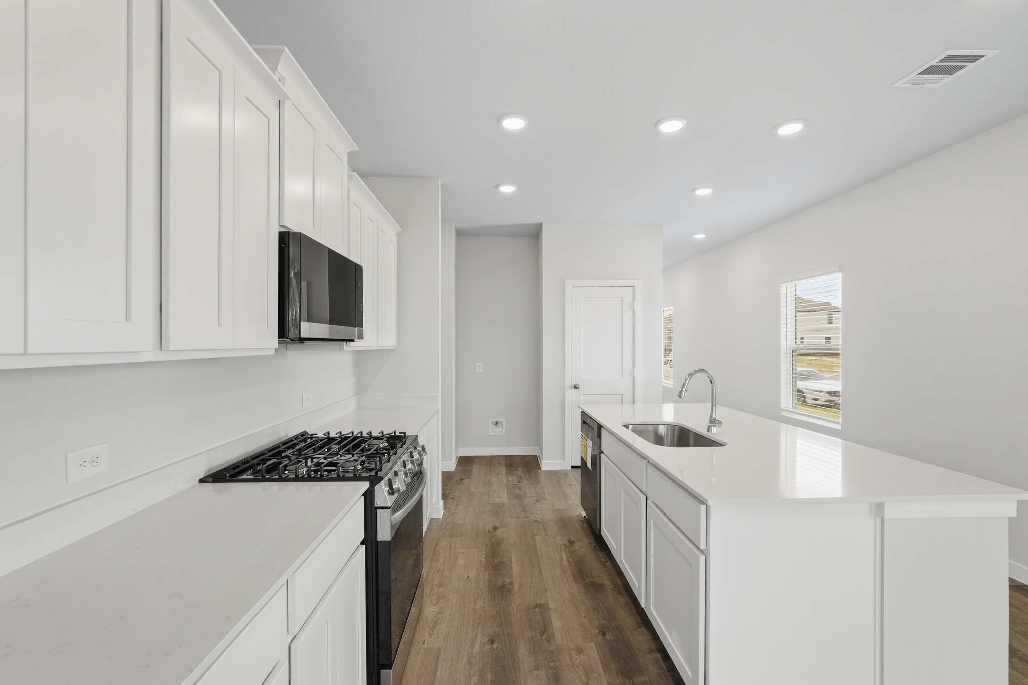 A kitchen with white cabinets.