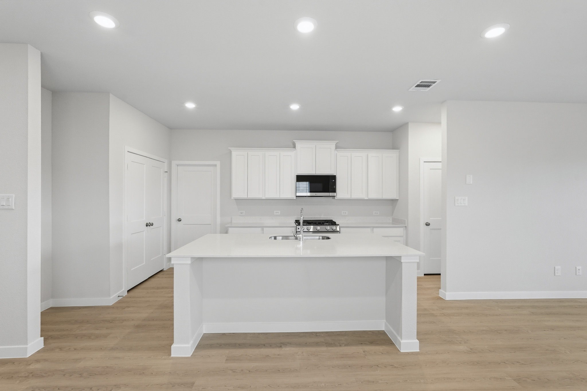 A kitchen with white cabinets.
