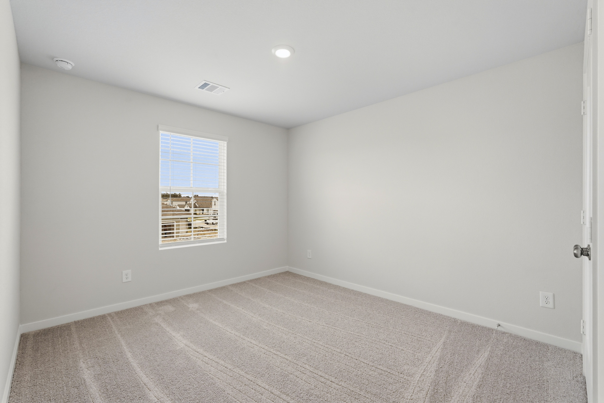 A room with a window and a rug.