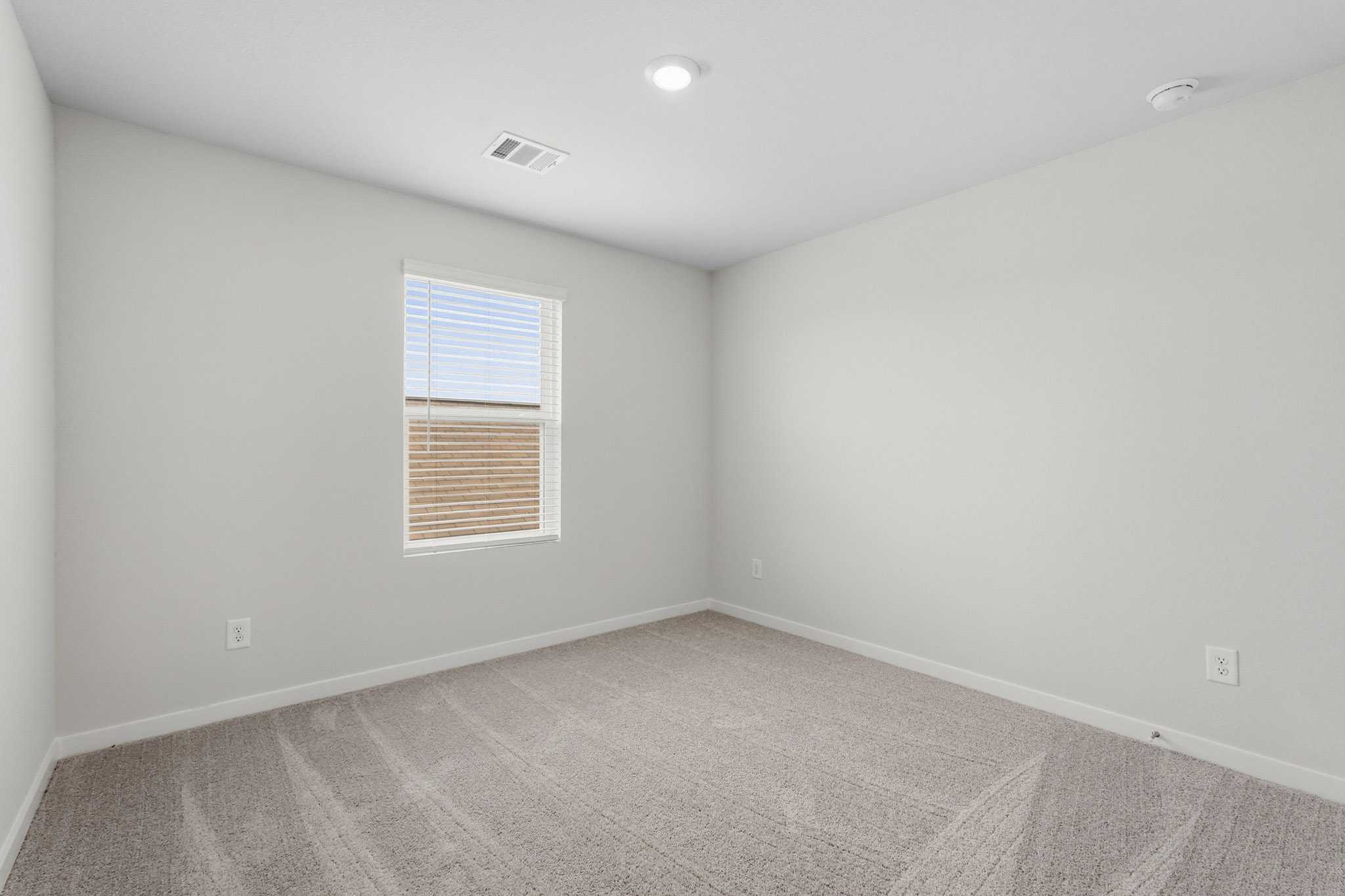 A room with a window and a carpet.