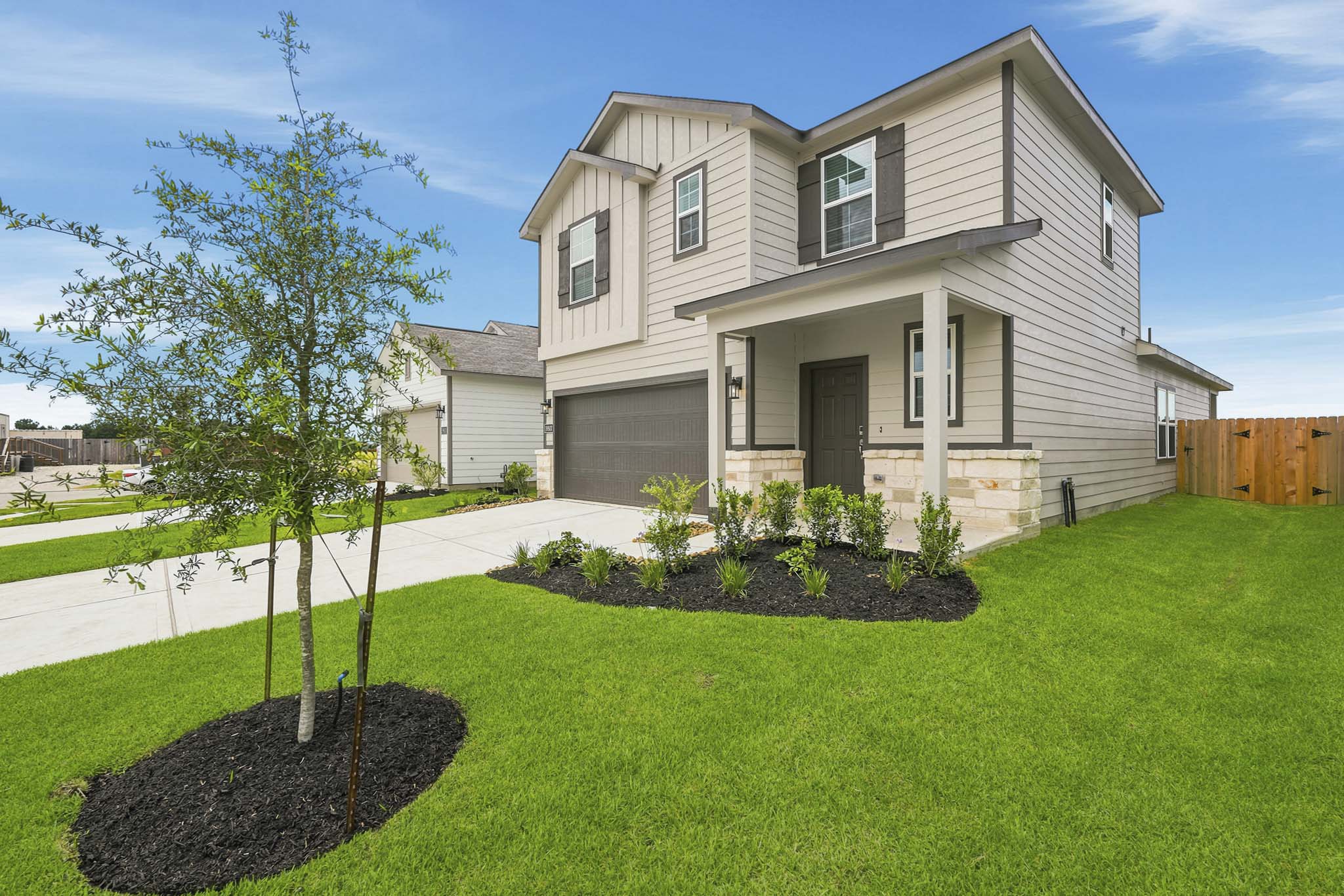 A house with a tree in the front yard.