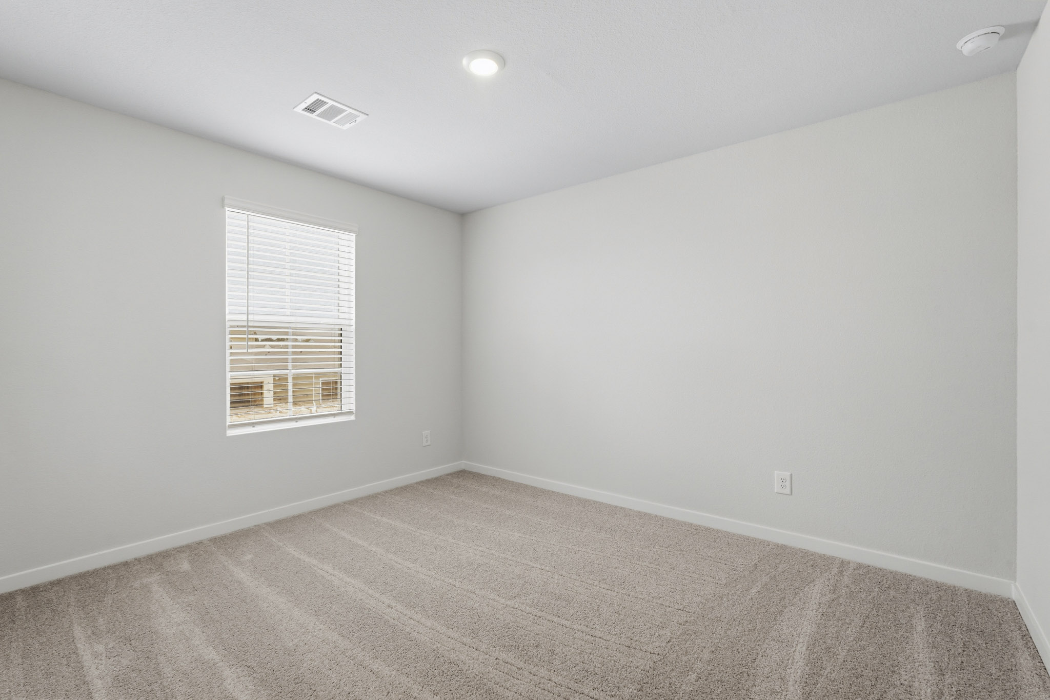 A room with a window and a carpet.