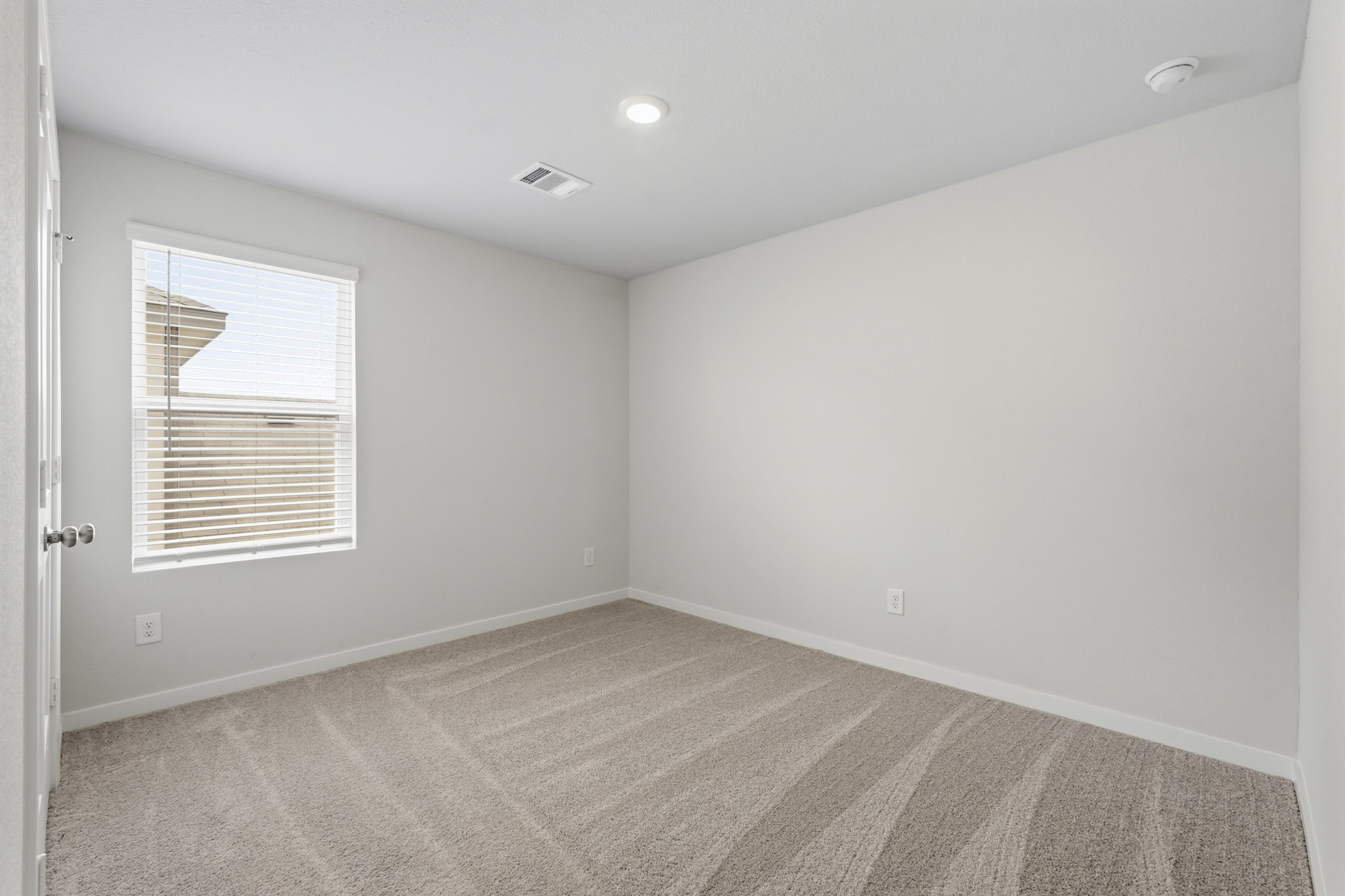 A room with a window and a rug.