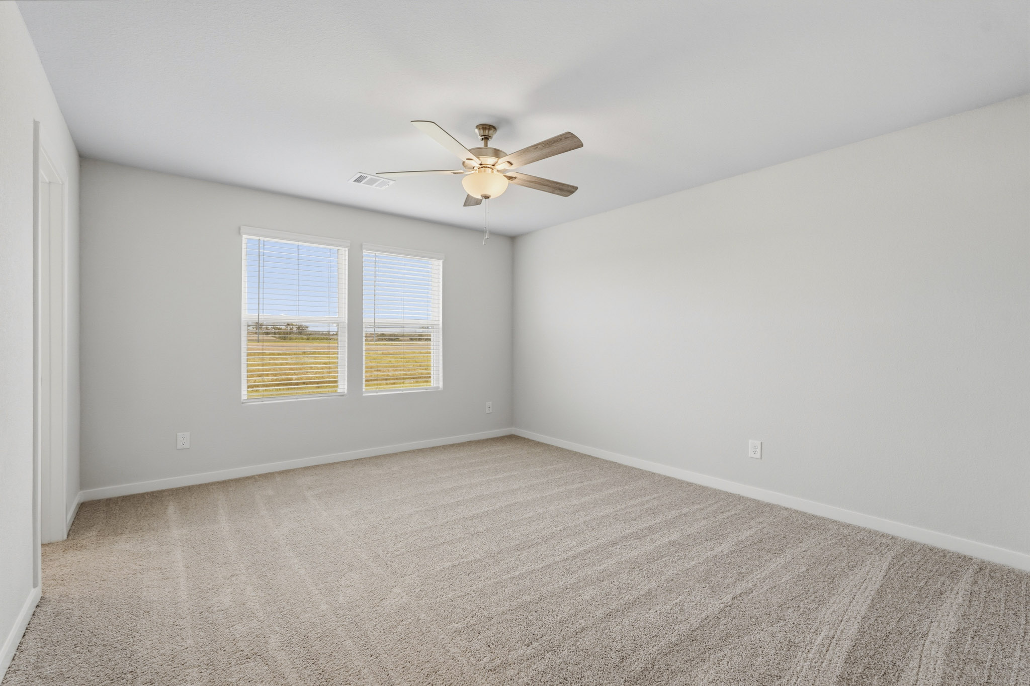 A room with a ceiling fan and a window.
