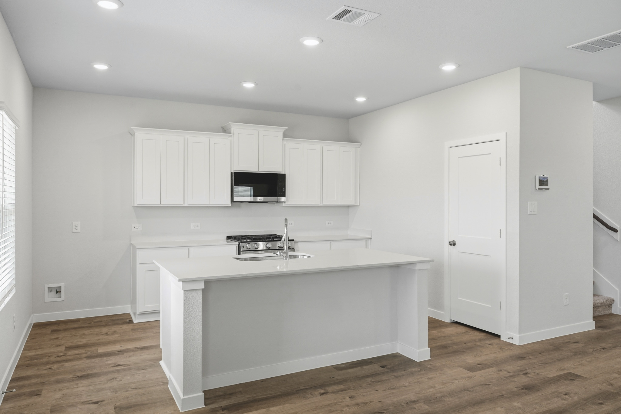 A kitchen with white cabinets.