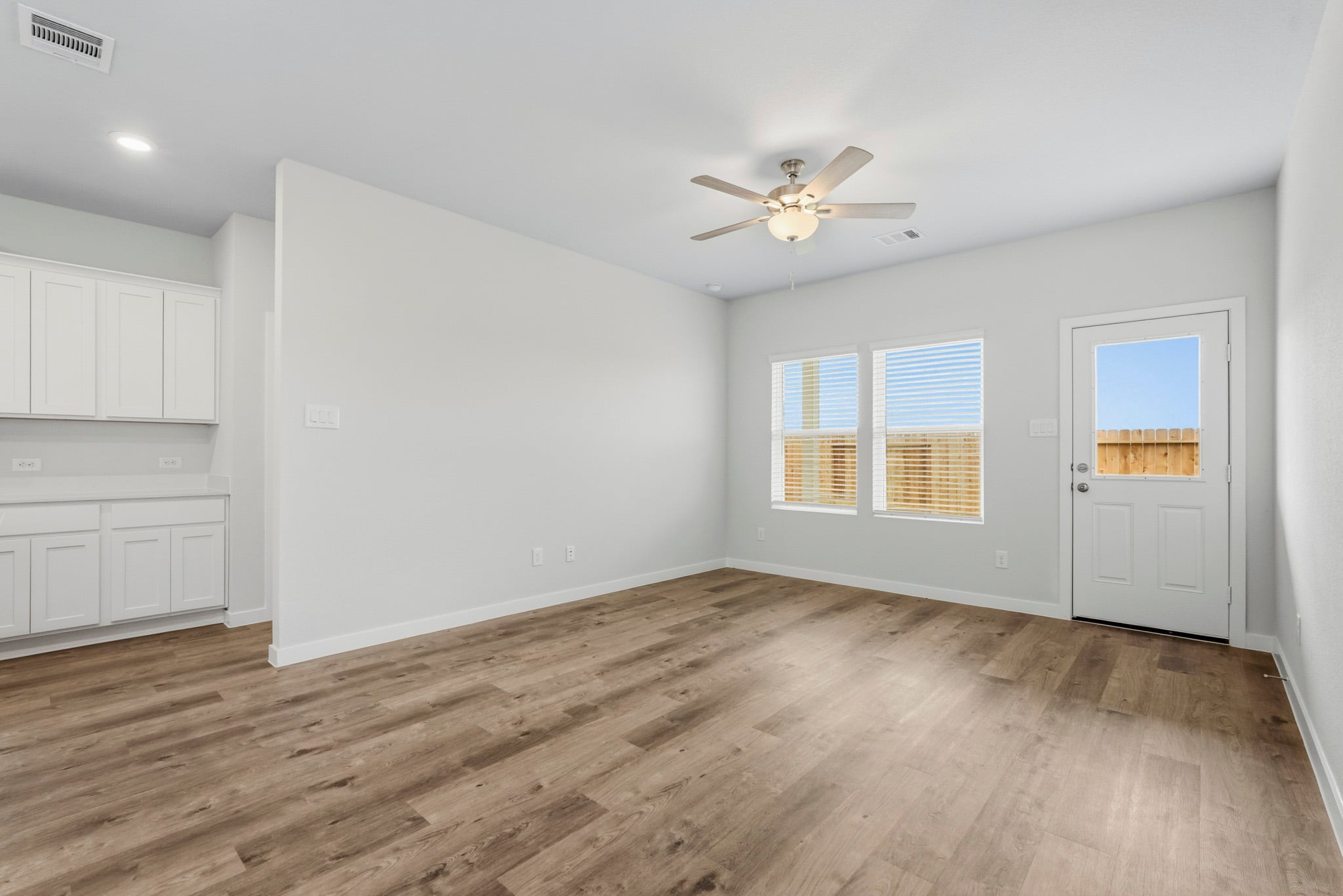 A room with a wood floor and a ceiling fan.