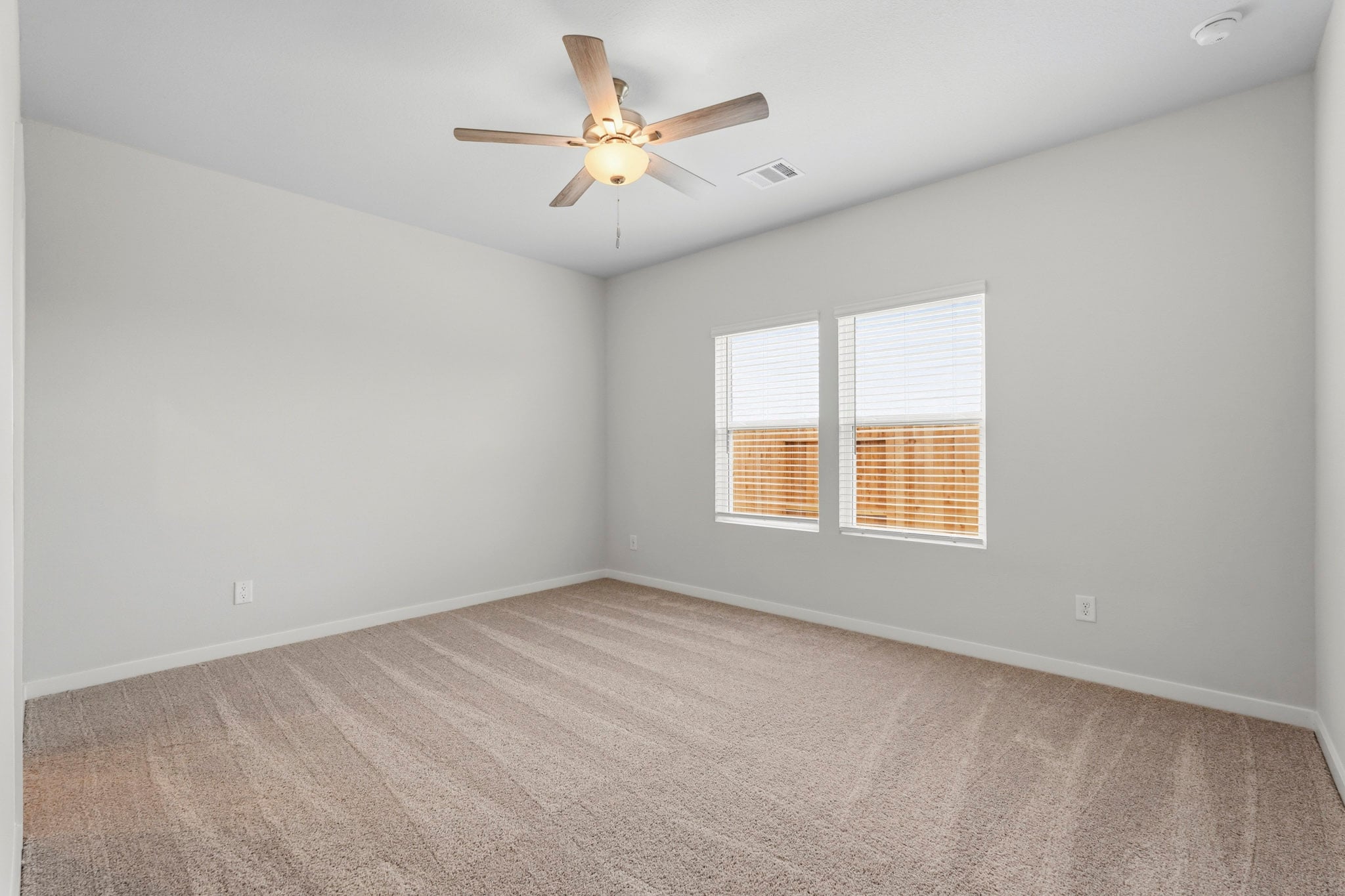 A room with a ceiling fan and a window.