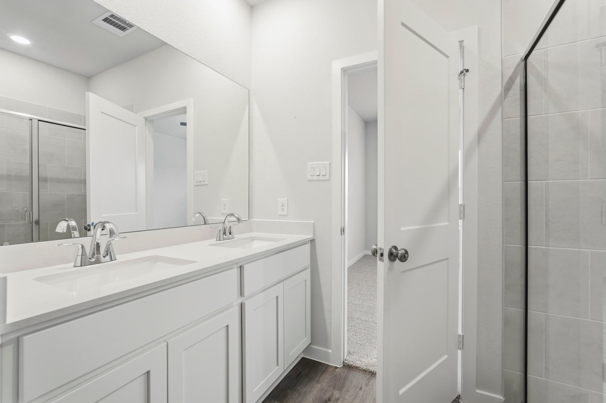 A bathroom with a sink and a shower unit.