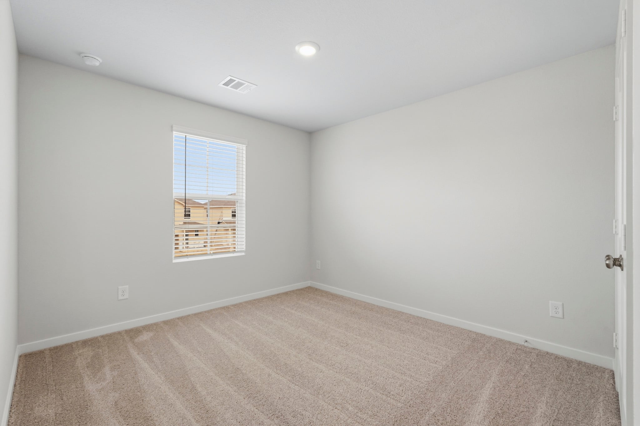 A room with a window and a carpet.