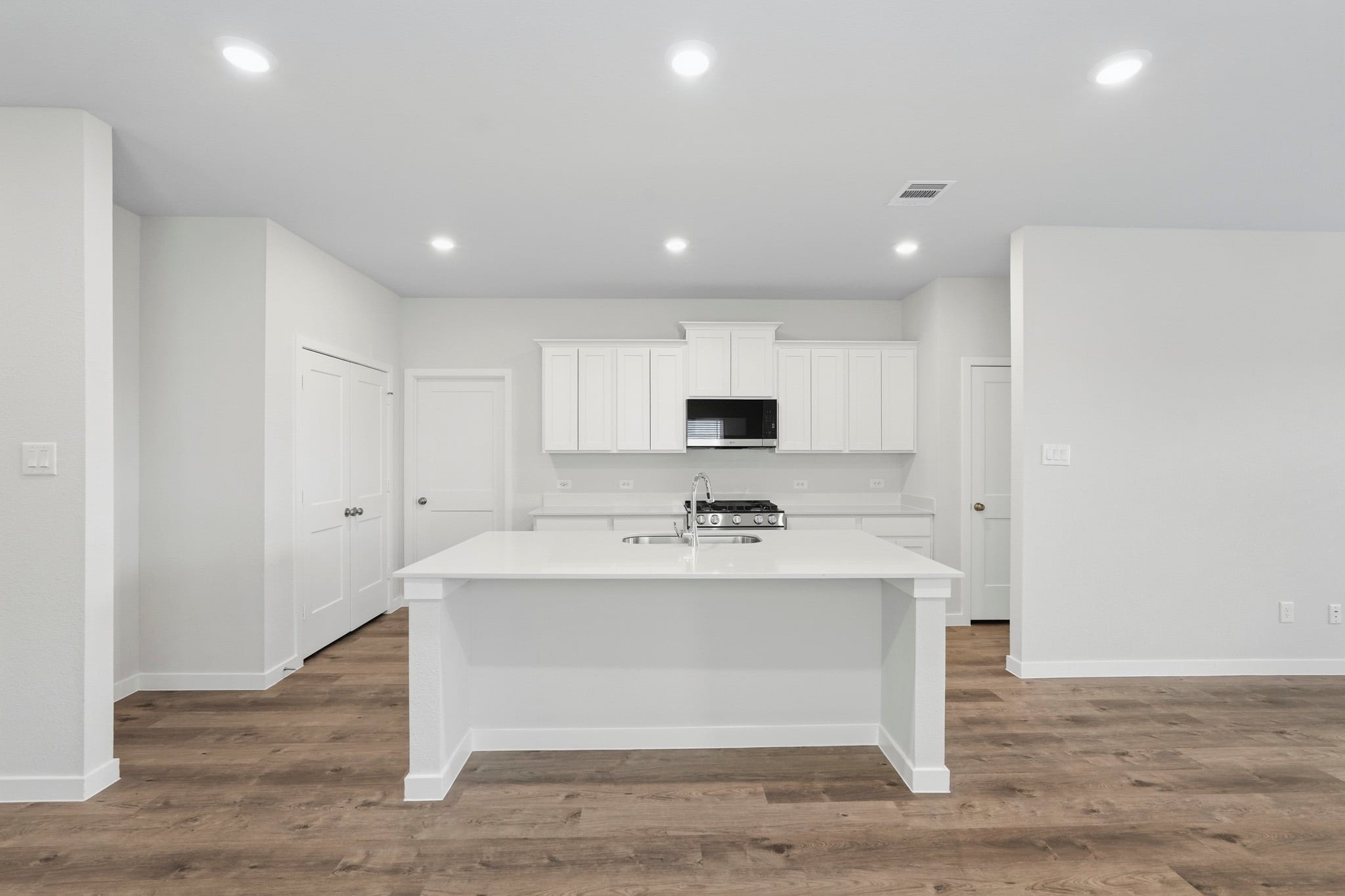 A kitchen with white cabinets.