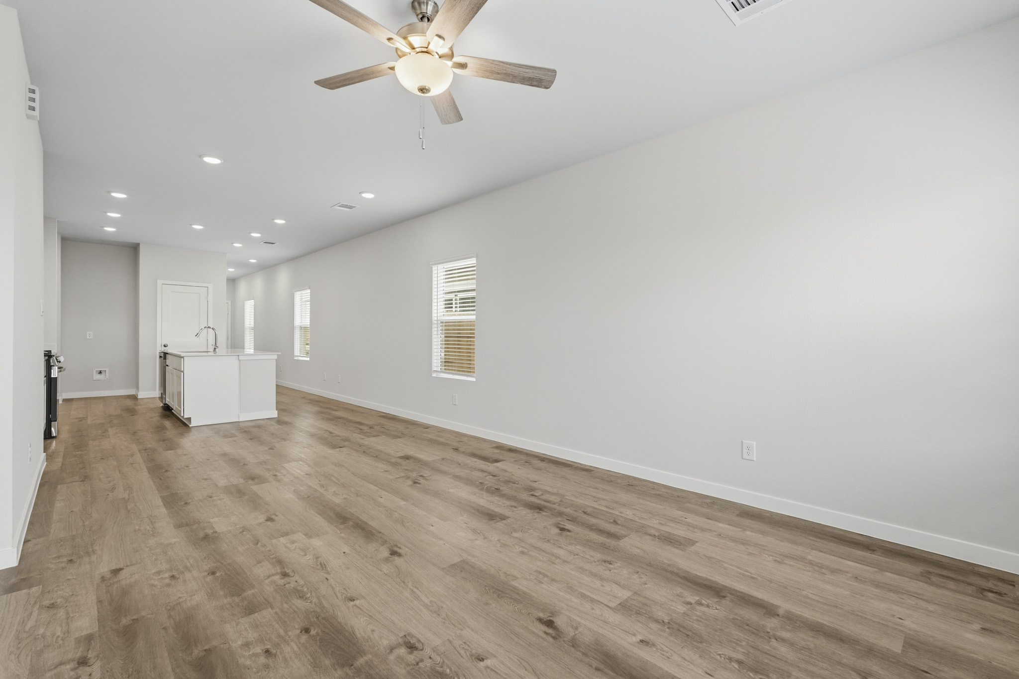 A room with a wood floor and a ceiling fan.