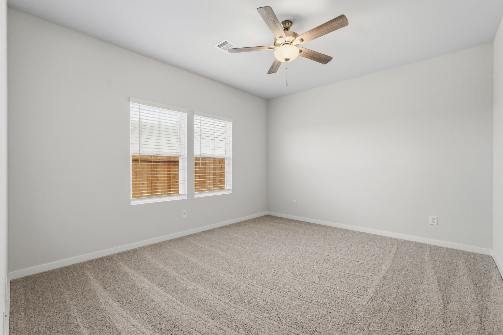 A room with a ceiling fan and a window.