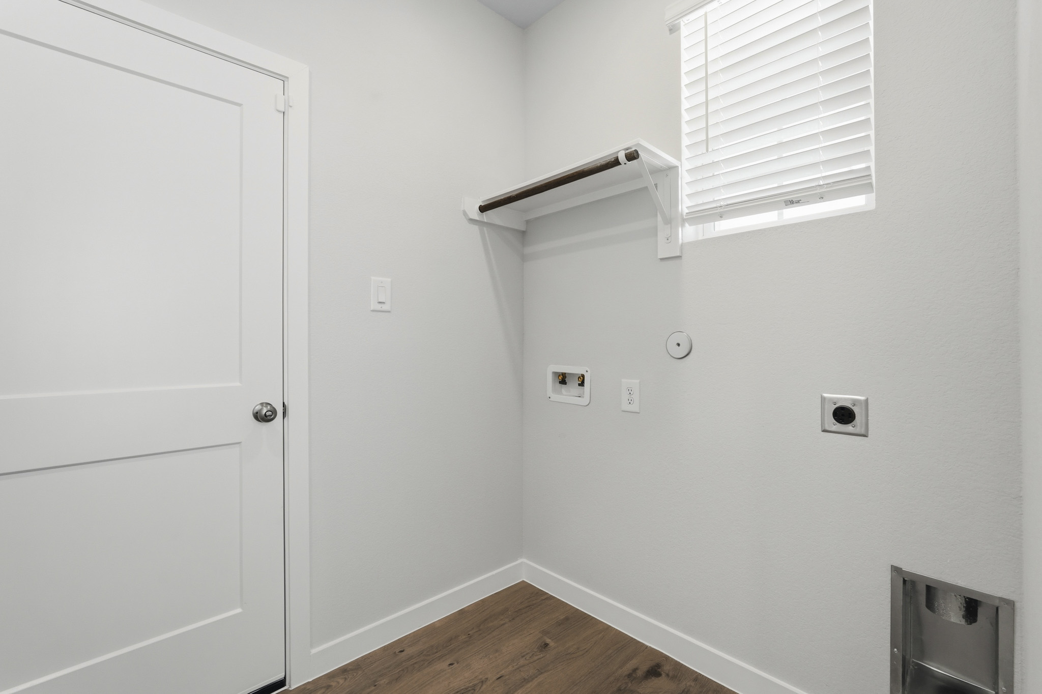 A room with white walls and a wood floor.