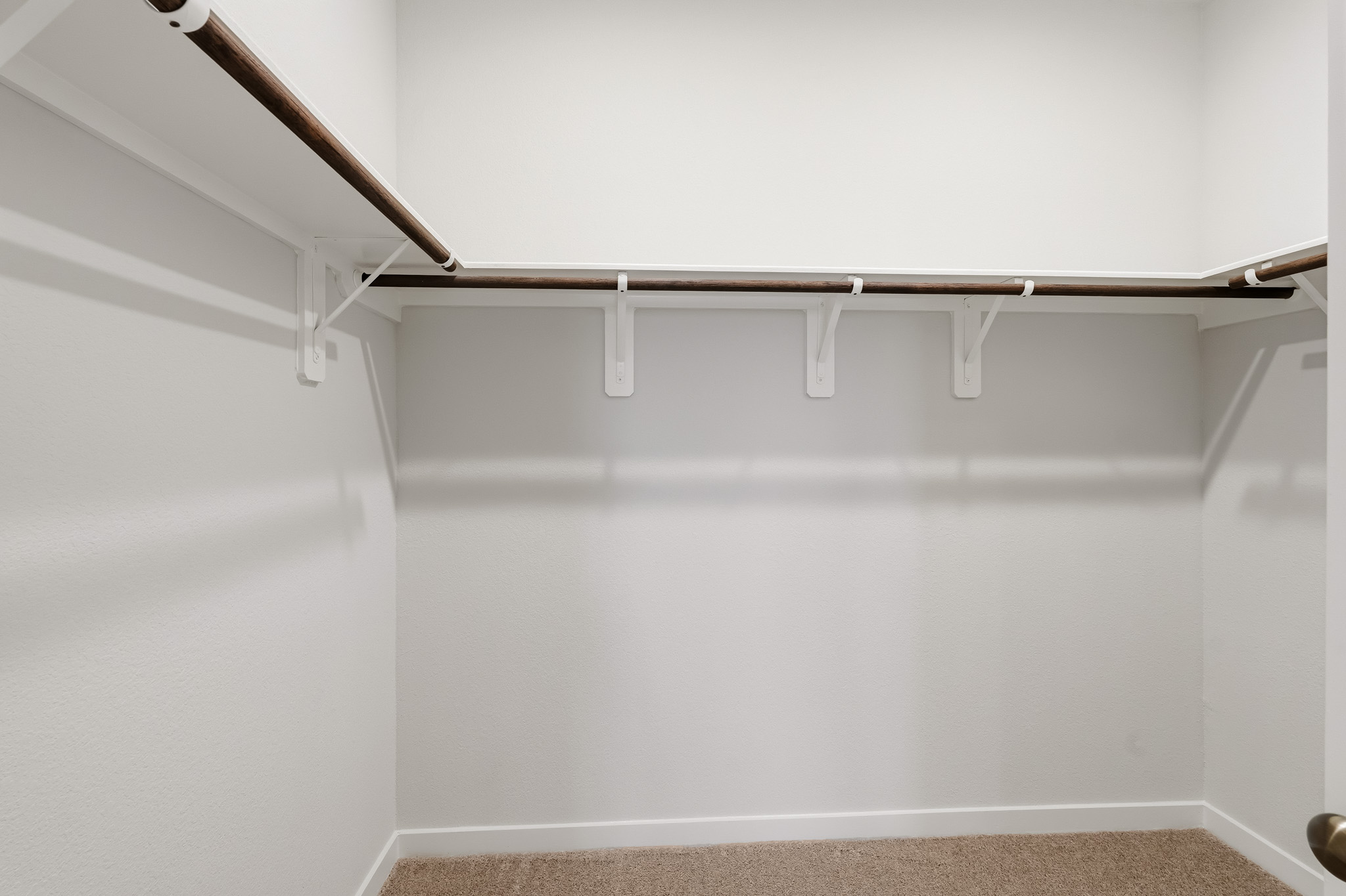 A white wall with a metal bar.