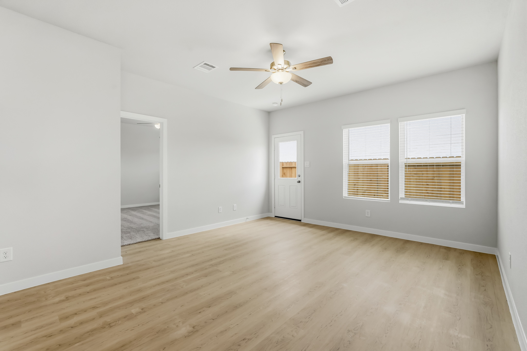 A room with a wood floor and a ceiling fan.