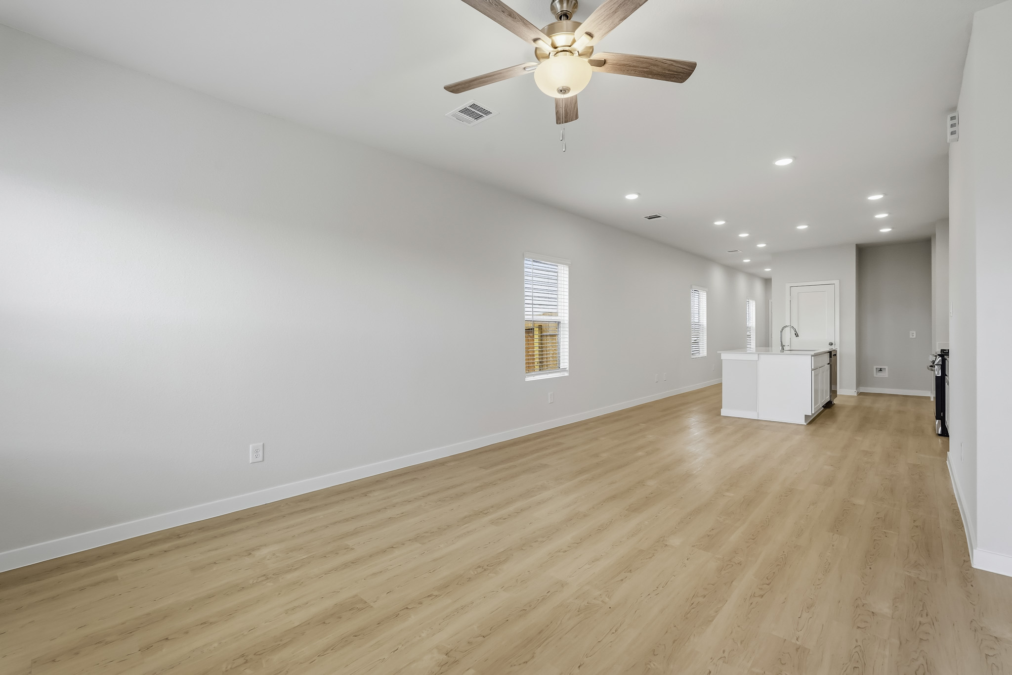 A room with a wood floor and a ceiling fan.