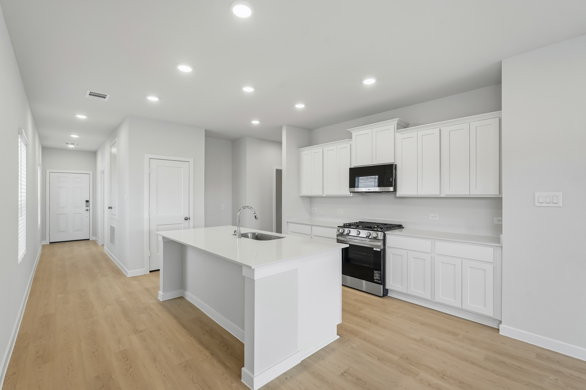 A kitchen with white cabinets.