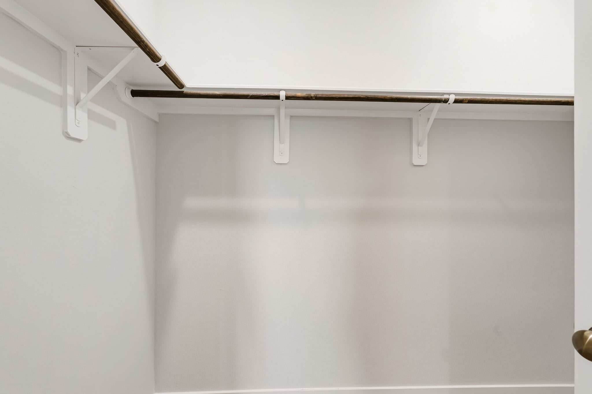 A white wall with a metal bar.
