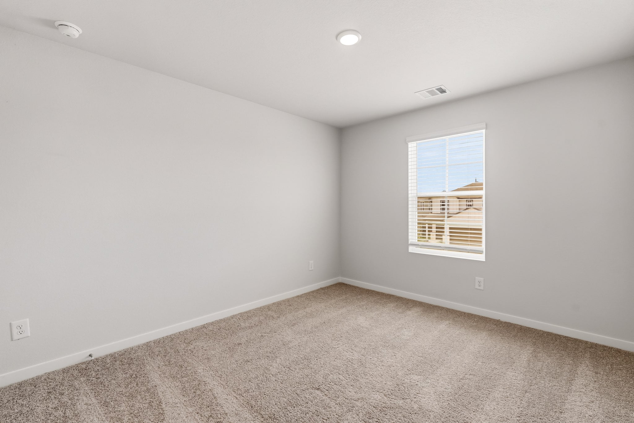 A room with a window and a carpet.
