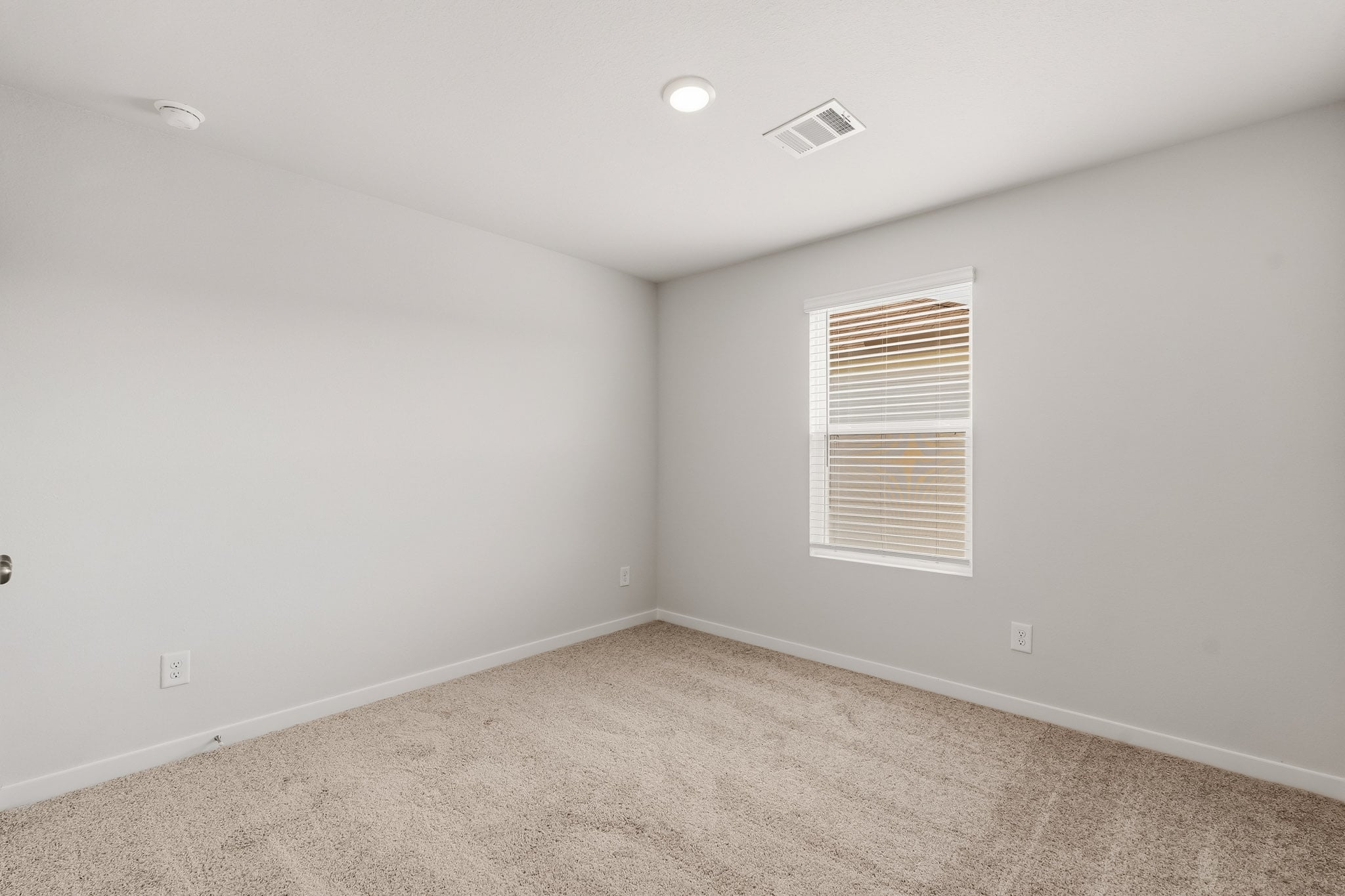 A room with a window and carpet.