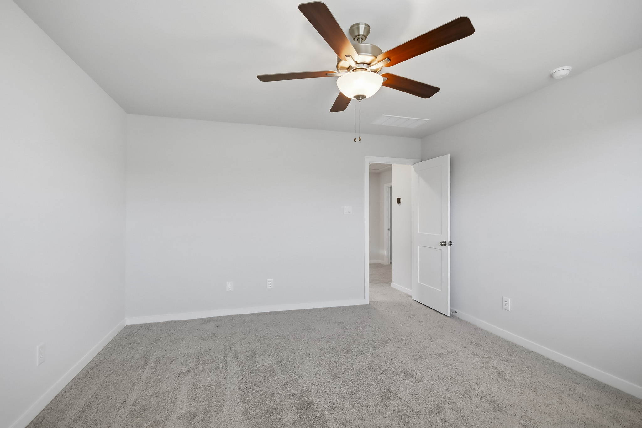 A room with a ceiling fan and a door.