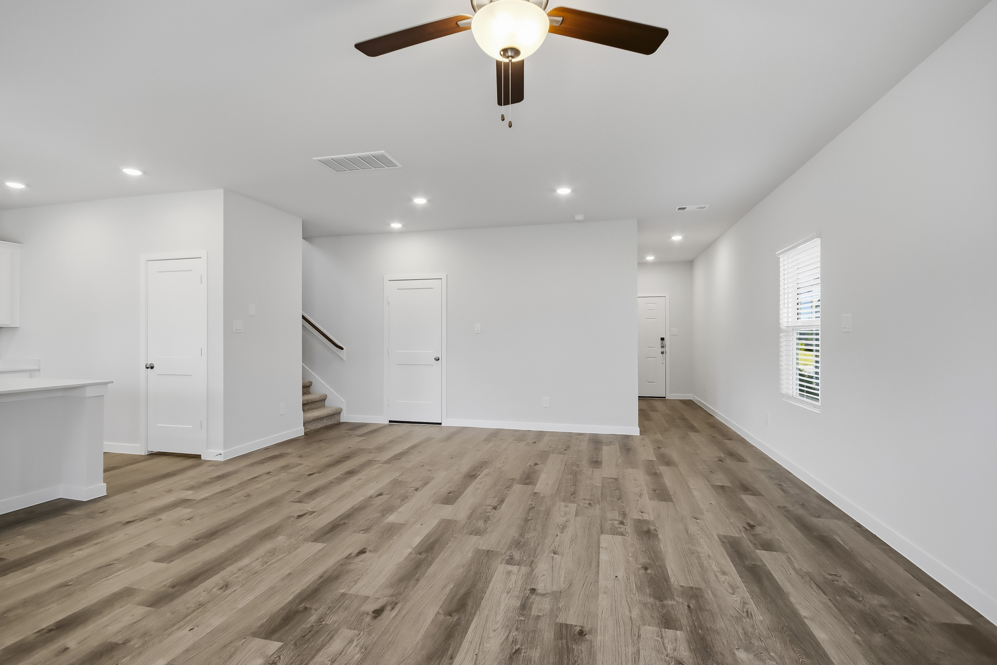 A room with white walls and a ceiling fan.